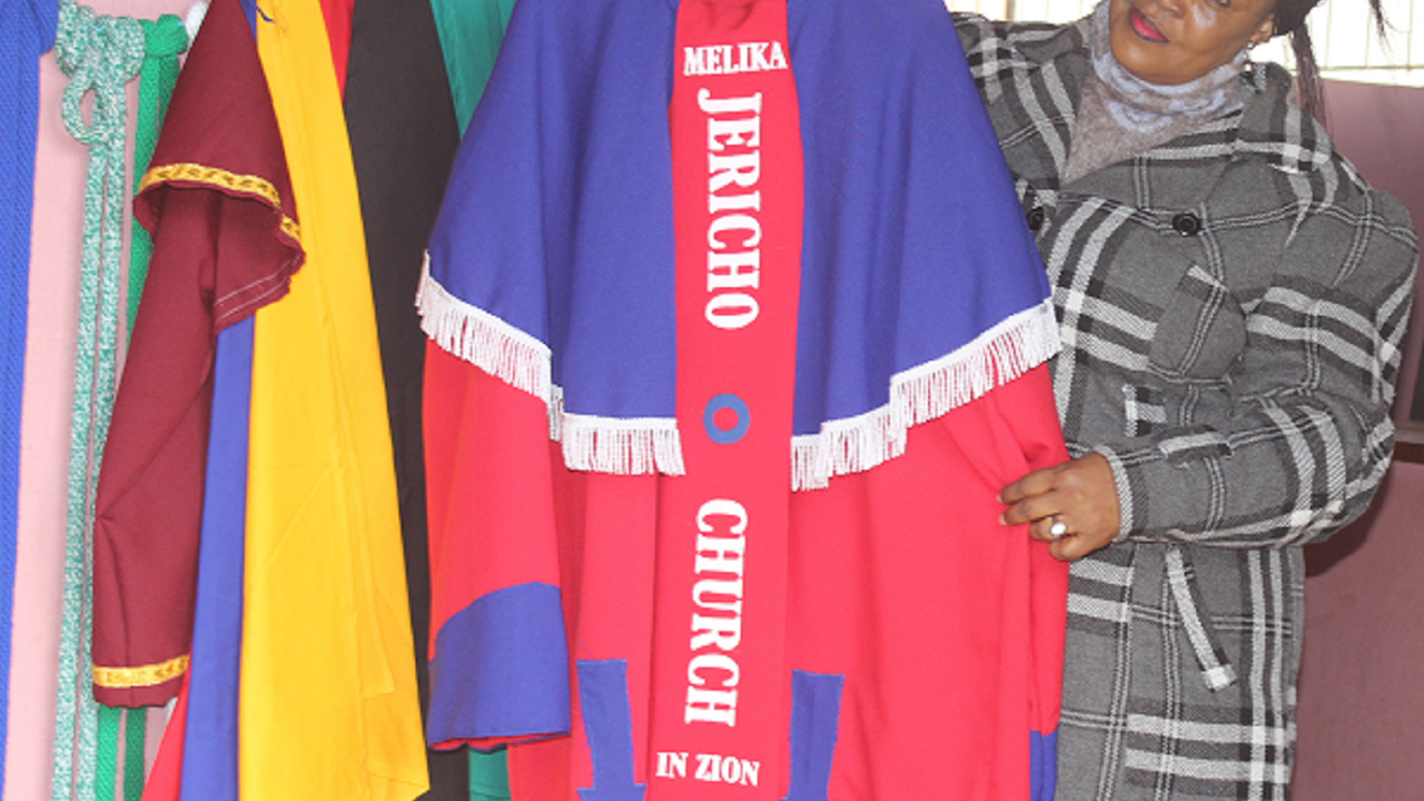 Dressmaker displaying her wares at the Mbabane market, Swaziland